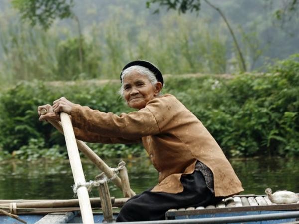 Bà lão lái thuyền trên dòng sông Ngô Đồng, Ninh Bình. Con sông này là con đường thủy duy nhất đưa du khách vào tham quan Tam Cốc.